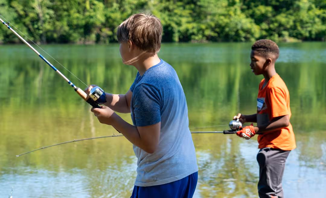 a group of boys fishing in the water