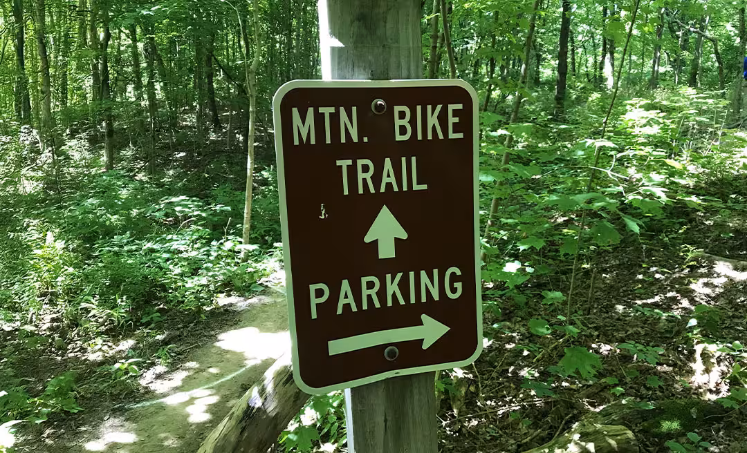 a sign on a post in the woods