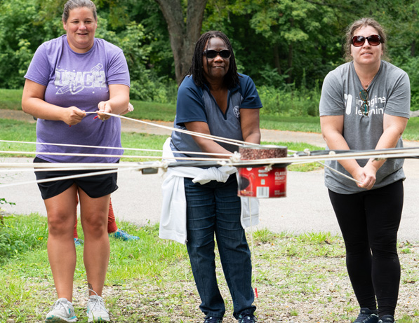 a group of women pulling a rope