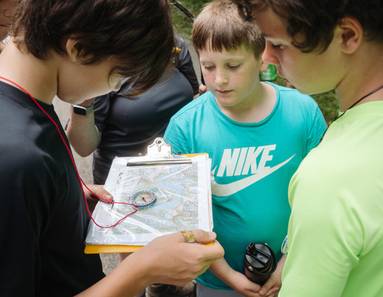 Children reading a map and compass