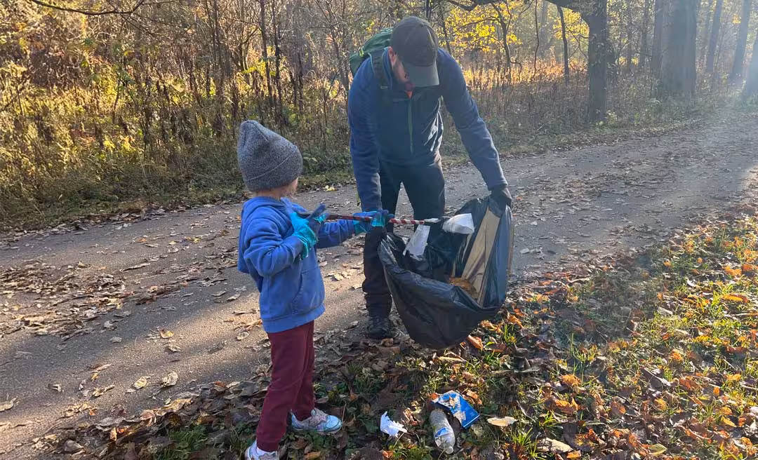 a man and child picking up trash