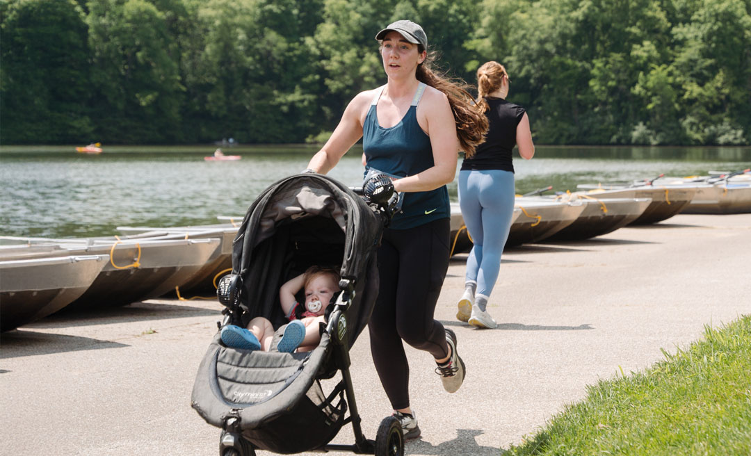 a woman running with a baby in a stroller