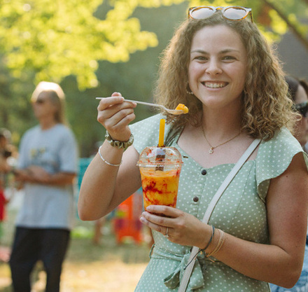 a woman holding a spoon and a drink