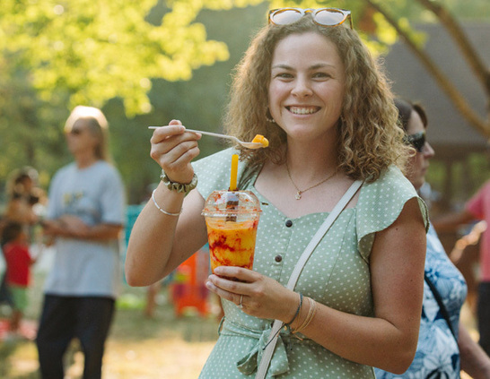 a woman holding a spoon and a drink