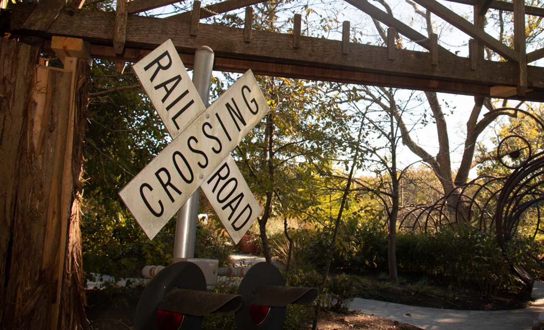 a railroad crossing sign in a garden