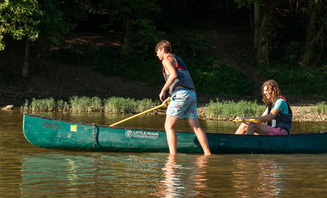 two boys in a canoe on a river
