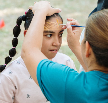 a woman painting a girl's face
