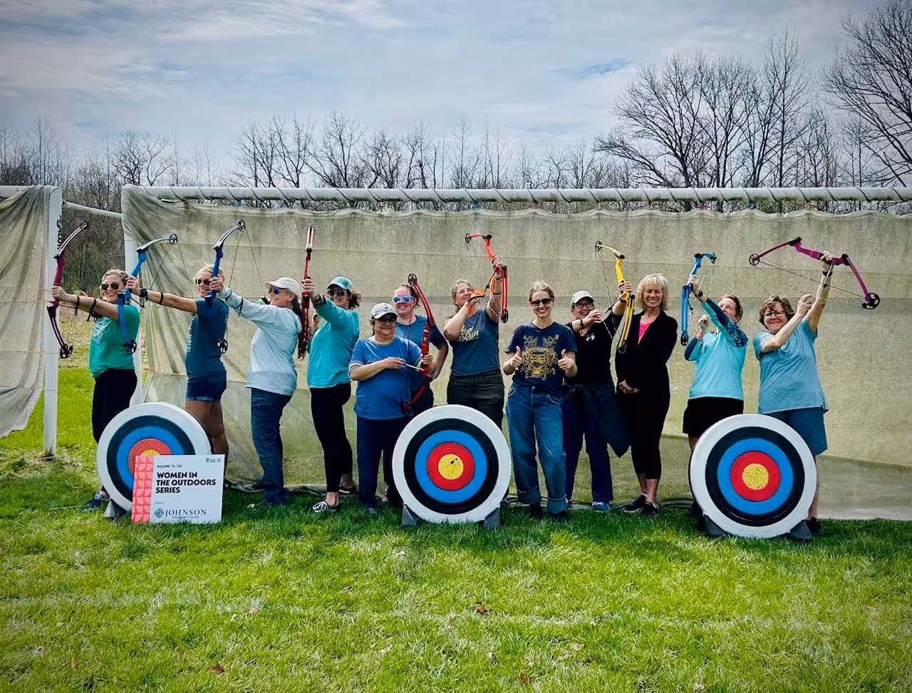 a group of people holding bows and targets