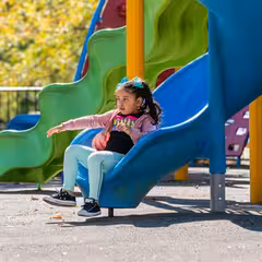 a girl sitting on a slide