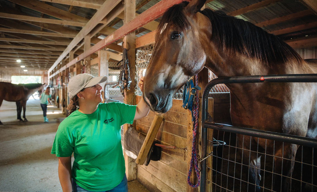 a woman petting a horse