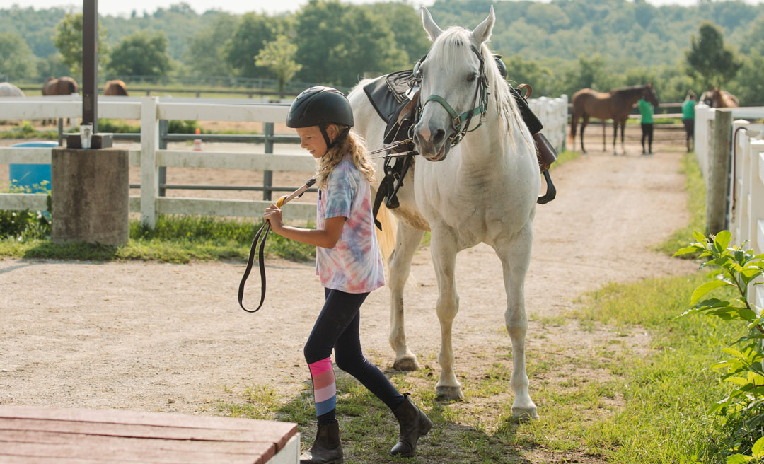 a girl with a helmet and a horse