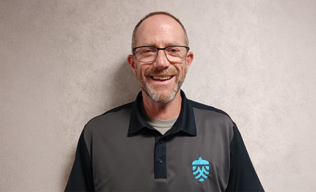 a man wearing glasses and a black and grey shirt
