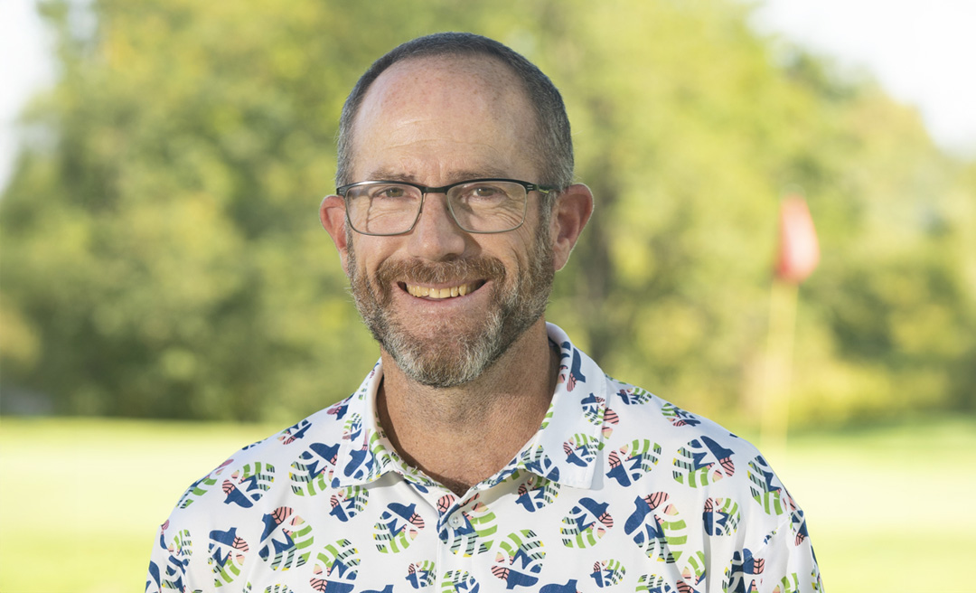 a man wearing glasses and a black and grey shirt