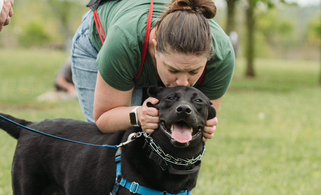 a woman kissing a dog